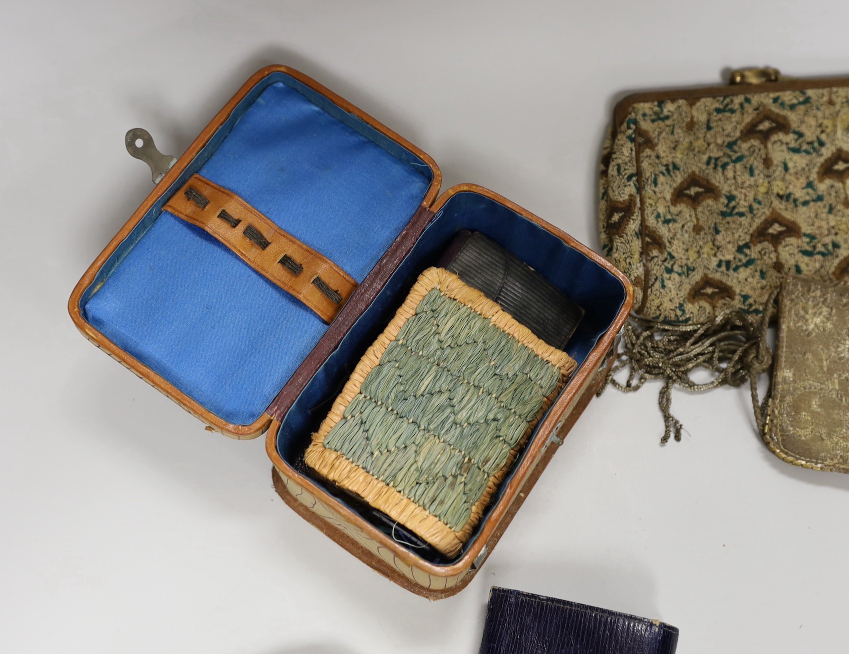A suitcase containing a collection of late 19th century leather sewing bags and containers, wooden darning mushrooms, etc